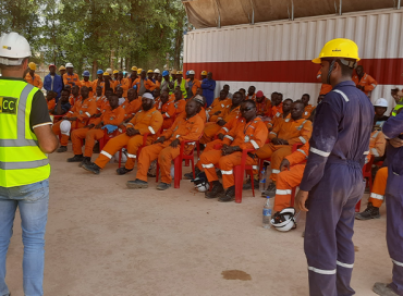 Superviseur discutant avec ses travailleurs sur l'importance de la santé et sécurité au travail. Chez Congo Contracting SA, nous nous engageons à maintenir des normes élevées pour assurer un environnement de travail sûr et protéger le bien-être de nos équipes.