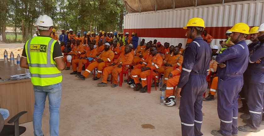 Superviseur discutant avec ses travailleurs sur l'importance de la santé et sécurité au travail. Chez Congo Contracting SA, nous nous engageons à maintenir des normes élevées pour assurer un environnement de travail sûr et protéger le bien-être de nos équipes.